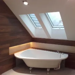 Biała wanna na nóżkach w łazience na poddaszu z drewnianą okładziną ściany i oświetleniem LED oraz dwoma oknami dachowymi.