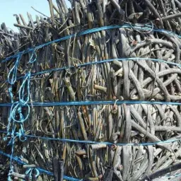 Stos zwiniętych węży PE, spiętych niebieskim sznurkiem, przygotowanych do transportu lub recyklingu.