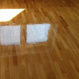 Błyszcząca, świeżo polakierowana drewniana podłoga parkietowa z widocznym odbiciem okna.