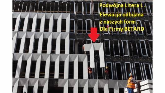 Montaż prefabrykowanej elewacji z betonu architektonicznego na budynku biurowym, widoczni pracownicy w kaskach i kamizelkach odblaskowych.