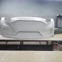 Biały, surowy element konstrukcyjny basenu z widocznymi wnękami na oświetlenie, leżący na stole warsztatowym w szarej przestrzeni roboczej.