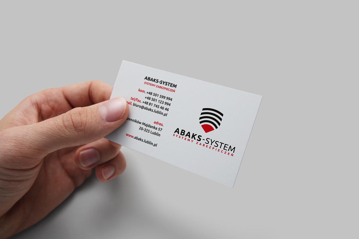 Dłoń trzymająca wizytówkę firmy Abaks-System Systemy Zabezpieczeń z Lublina, prezentującą logo i dane kontaktowe.