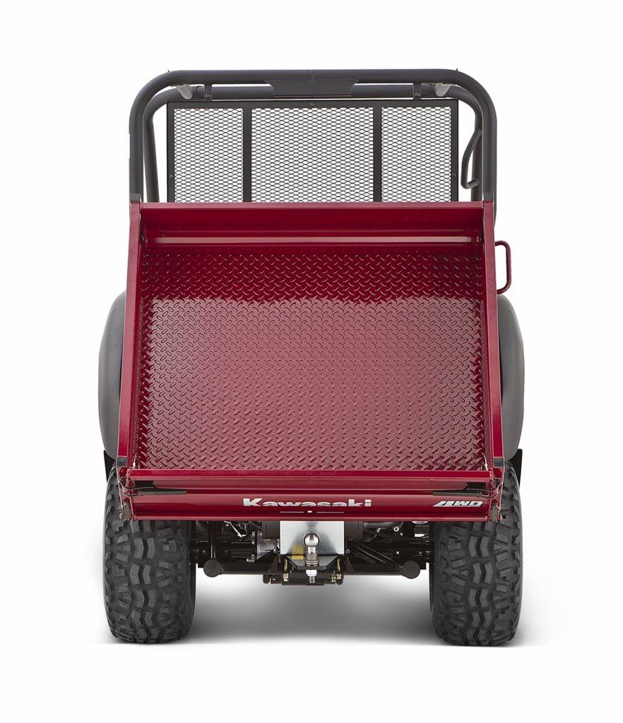 Widok z tyłu czerwonego pojazdu użytkowego Kawasaki MULE 600 UTV z oponami terenowymi i metalową kratą ochronną na białym tle.