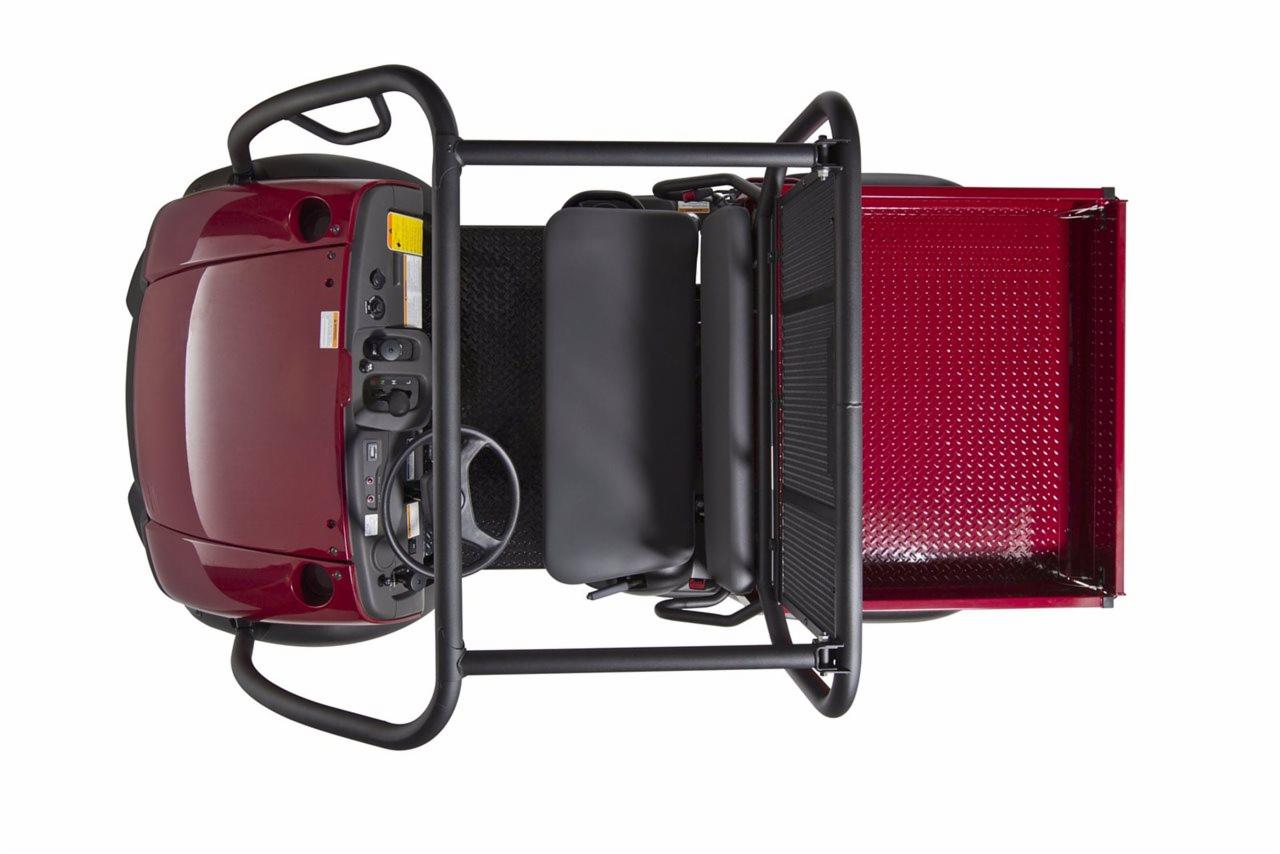 Widok z góry na czerwony pojazd użytkowy UTV Kawasaki MULE 600 z czarną ramą ochronną i skrzynią ładunkową o diamentowej fakturze.