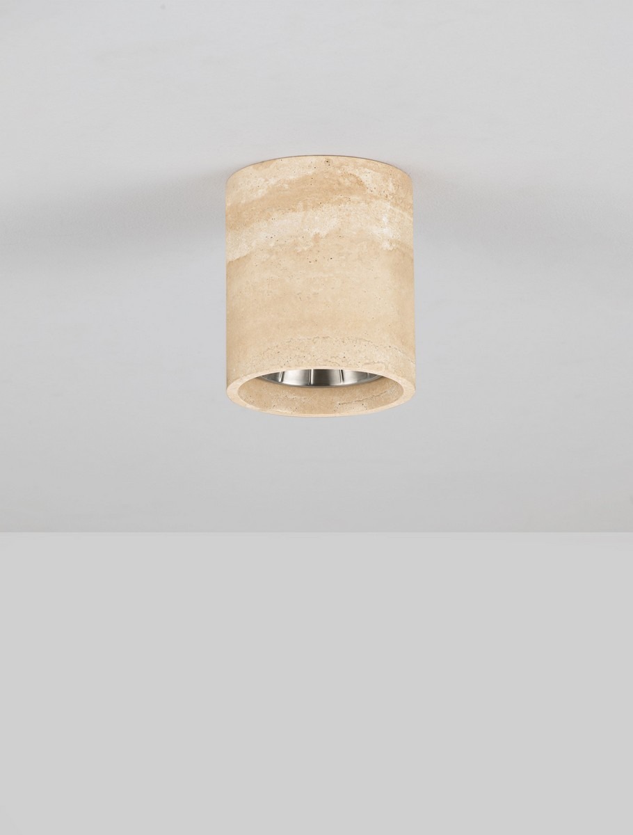 Beżowa, cylindryczna lampa sufitowa z efektem trawertynu, zamontowana na białym suficie. Widoczne metalowe wnętrze oprawy. Minimalistyczny design, stonowana kolorystyka.