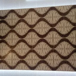 Ściana wyłożona dekoracyjnymi płytami gipsowymi z motywem fal i kwiatów, podświetlona od dołu, tworząca efektowną teksturę.