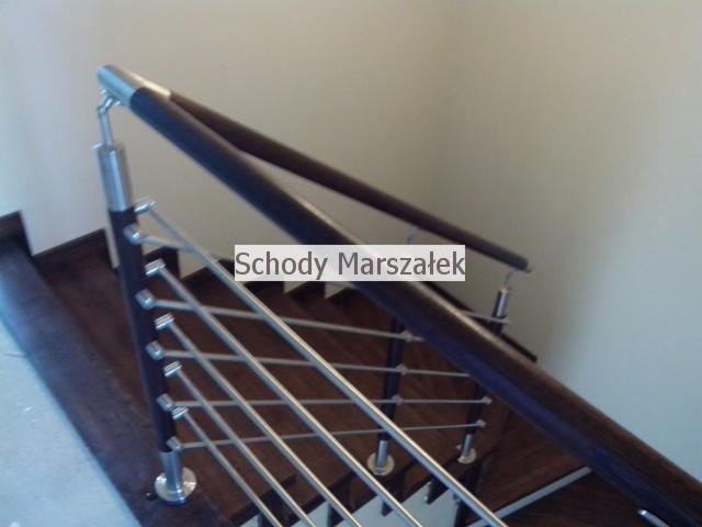 Nowoczesne schody z ciemnego drewna z balustradą z metalowych prętów i drewnianą poręczą, widok z góry, oświetlenie dzienne, minimalistyczny design.