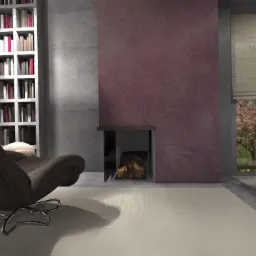 Nowoczesny salon z obrotowym fotelem, betonową ścianą, regałem z książkami i kominkiem z widokiem na kwitnące drzewa za oknem.