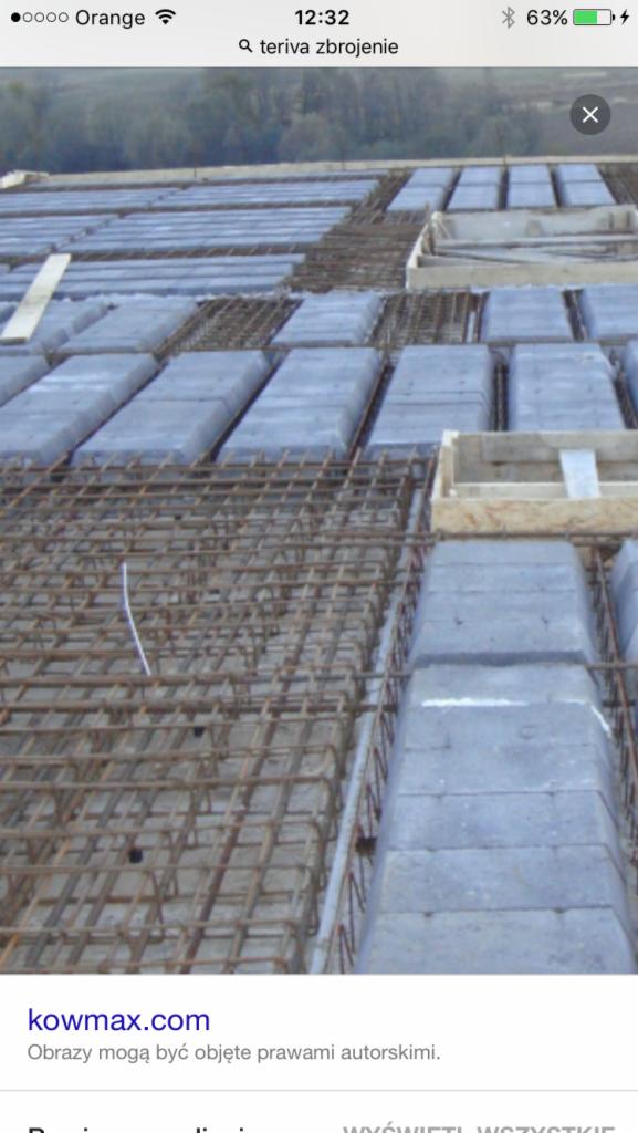 Zbrojenie stropu Teriva z szarego betonu i stalowych prętów, widok z góry, etap budowy. Stalowa siatka zbrojeniowa ułożona na betonowych elementach stropowych.