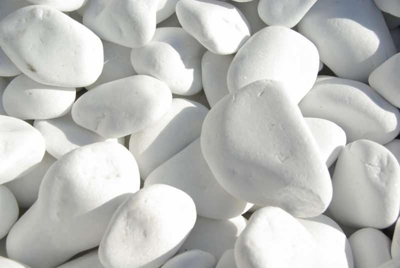 Białe, gładkie otoczaki w dużym zbliżeniu, tworzące jednolitą, jasną powierzchnię. Idealne do dekoracji ogrodów i wnętrz, dodające elegancji i nowoczesnego charakteru.