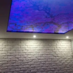 Ściana z białej cegły dekoracyjnej i podświetlany sufit z efektem nieba w Mysłowicach, oświetlenie punktowe.