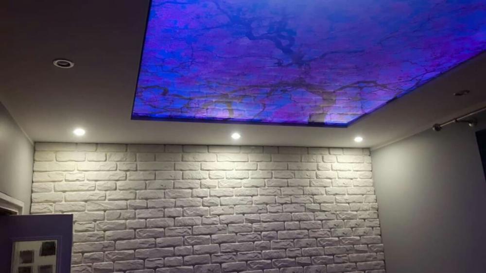 Ściana z białej cegły dekoracyjnej i podświetlany sufit z efektem nieba w Mysłowicach, oświetlenie punktowe.