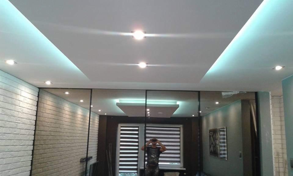 Nowoczesna łazienka z podwieszanym sufitem z oświetleniem LED, szklaną ścianą działową i dekoracyjną ścianą z białej cegły.