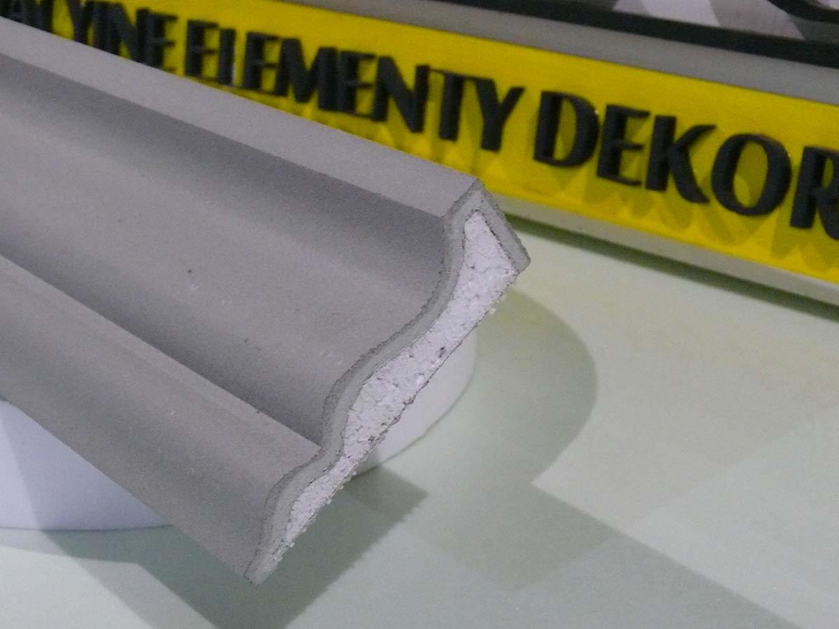 Szary profil elewacyjny z polistyrenu ekspandowanego, dekoracyjny element wykończeniowy, widoczny przekrój z charakterystycznym wzorem.