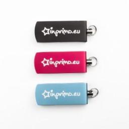 AZmedia (tel. ) - Trzy pendrive'y reklamowe w kolorach czarnym, różowym i błękitnym, z nadrukowanym logo 'inprimo.eu' i metalowym kółkiem do kluczy, ułożone pionowo na białym tle.