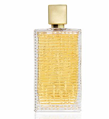 Perfumy w prostokątnym flakonie z poziomymi żłobieniami i złotym korkiem, prezentowane na białym tle. Widoczne detale tekstury szkła i złocenia.