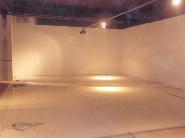 Przygotowanie podłoża pod posadzkę: wyrównana powierzchnia z widocznymi płytami izolacyjnymi, surowy stan wnętrza z elementami instalacji na suficie.