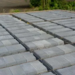 Szare prefabrykaty betonowe ułożone na stropie z widocznym zbrojeniem, przygotowane do zalania. Budowa domu w trakcie realizacji, widok z góry.