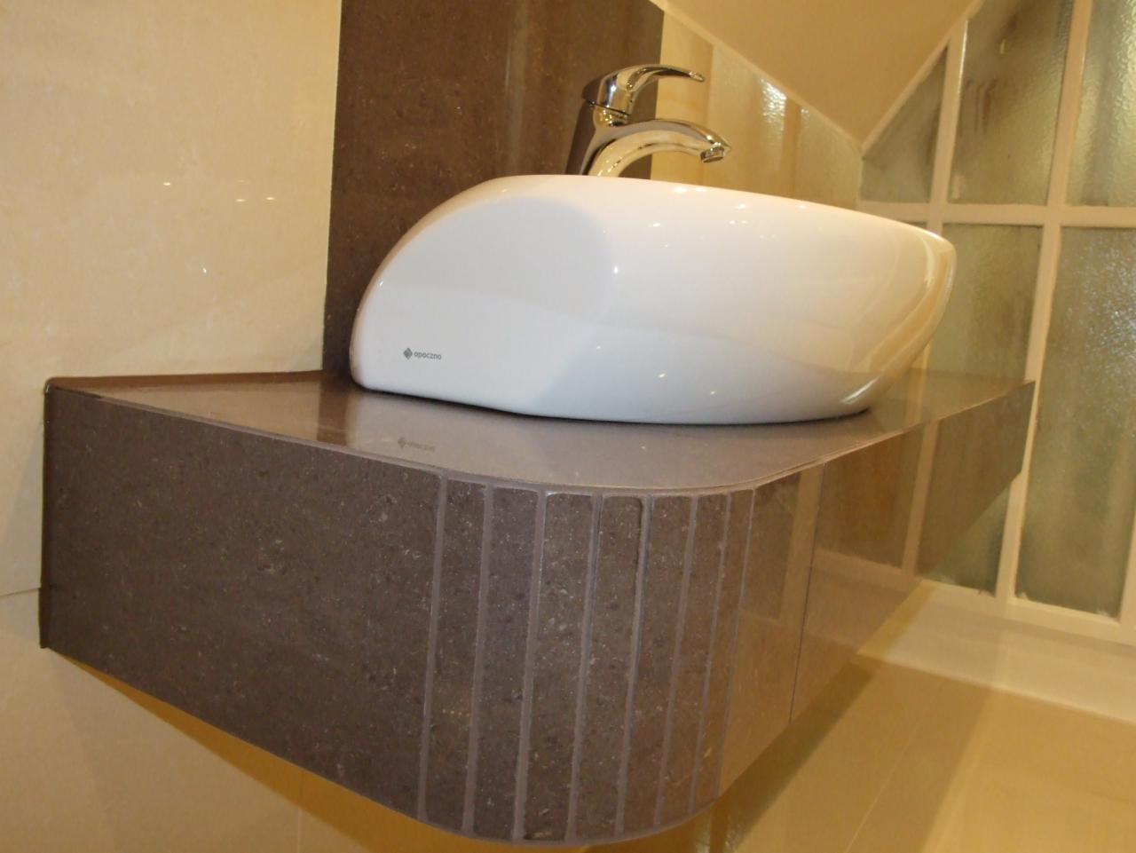 Nowoczesna umywalka nablatowa w Przemyślu, z chromowaną baterią, osadzona na blacie z mozaiki. Eleganckie wykończenie łazienki.