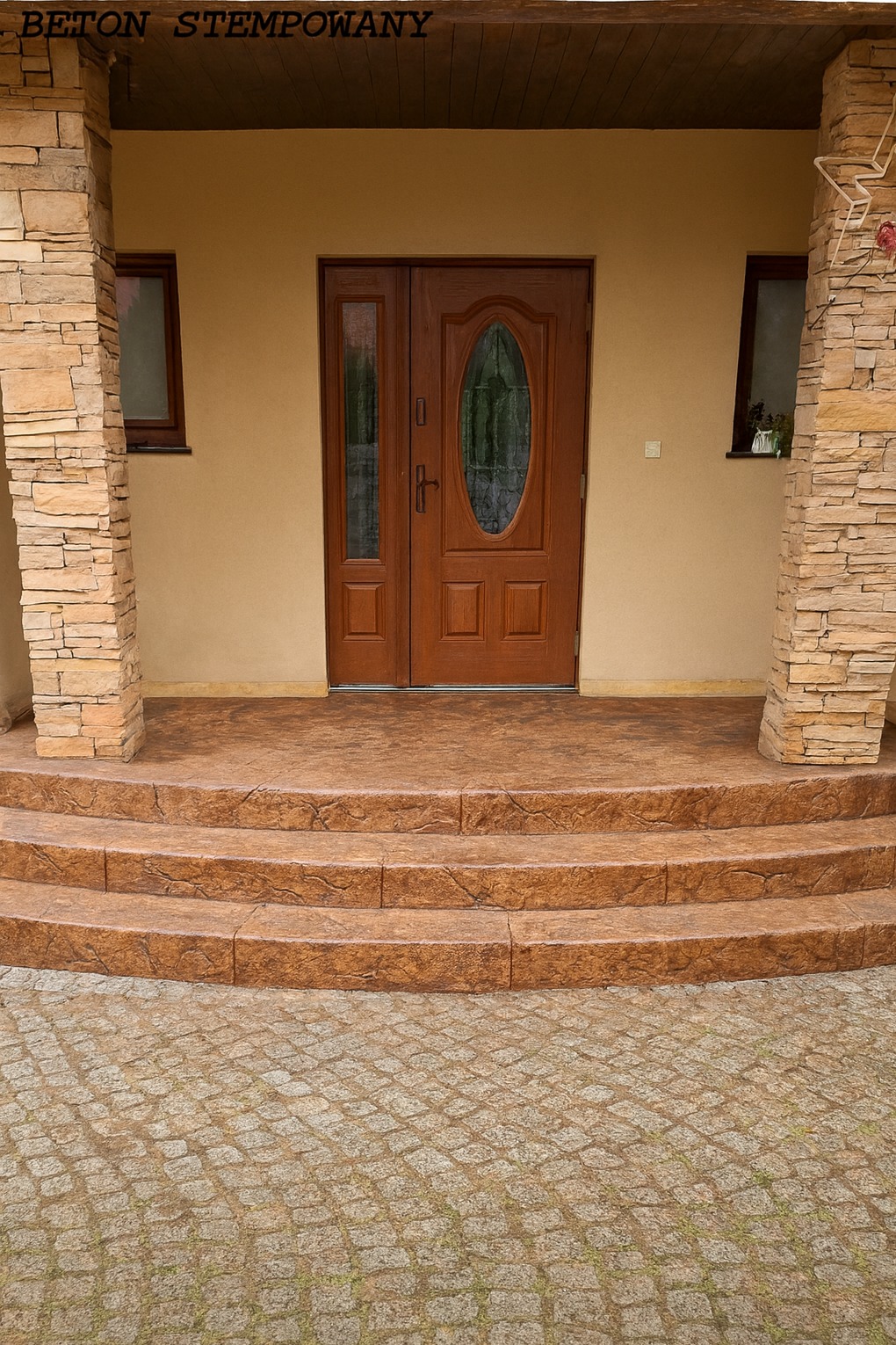 Stylowe wejście do domu z brązowymi, stemplowanymi schodami i kamienną kostką brukową. Kamienne filary po bokach drzwi. Ciepła kolorystyka.