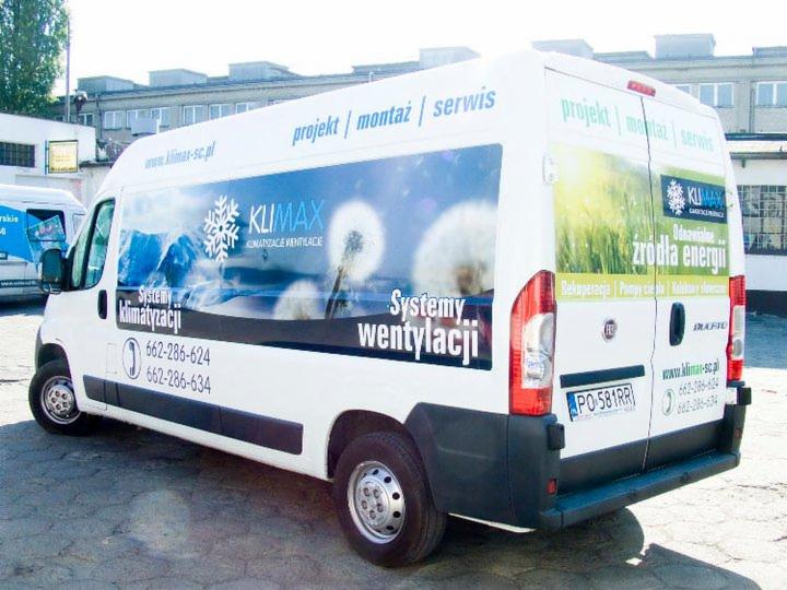 Biały van z grafiką firmy Klimax, prezentujący systemy klimatyzacji i wentylacji. Widoczne logo, numery telefonów i hasło: 'Odnawialne źródła energii'.