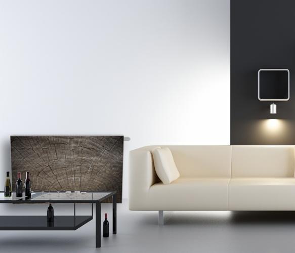 Designerski grzejnik dekoracyjny z motywem przekroju drewna w nowoczesnym salonie z beżową sofą i czarnym stolikiem kawowym.