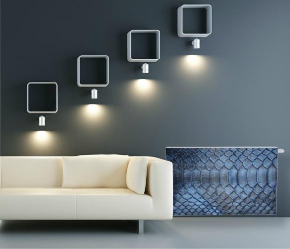 Nowoczesny grzejnik dekoracyjny z motywem skóry węża w salonie z białym narożnikiem i minimalistycznymi lampami ściennymi.