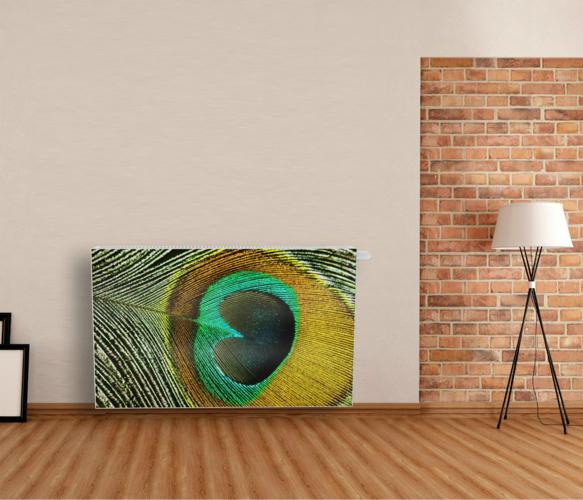 Grzejnik dekoracyjny z motywem pawiego pióra w Tczew, stojący na tle ceglanej ściany i drewnianej podłogi. Nowoczesny design, unikalny wzór.