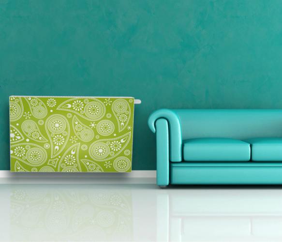 Ozdobny grzejnik w zielono-białe wzory paisley, dopasowany kolorystycznie do ściany i sofy w tle, tworzy spójną, nowoczesną aranżację wnętrza.