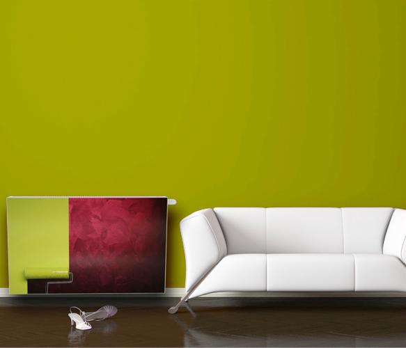 Dekoracyjny grzejnik z motywem malarskim w nowoczesnym wnętrzu z białą sofą i butami. Akcent kolorystyczny na zielonej ścianie.