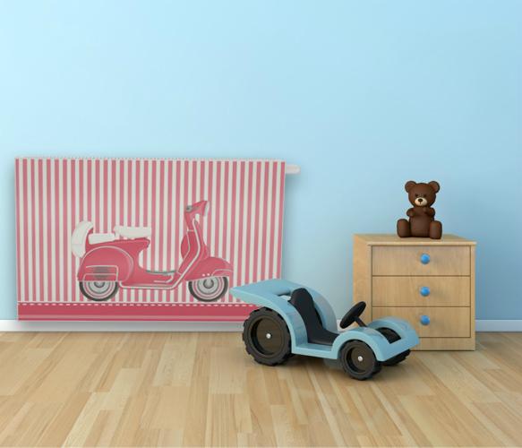 Grzejnik z nadrukiem różowego skutera w pokoju dziecięcym, obok drewniana komoda z misiem i niebieski jeździk. Pastelowe kolory, drewniana podłoga.