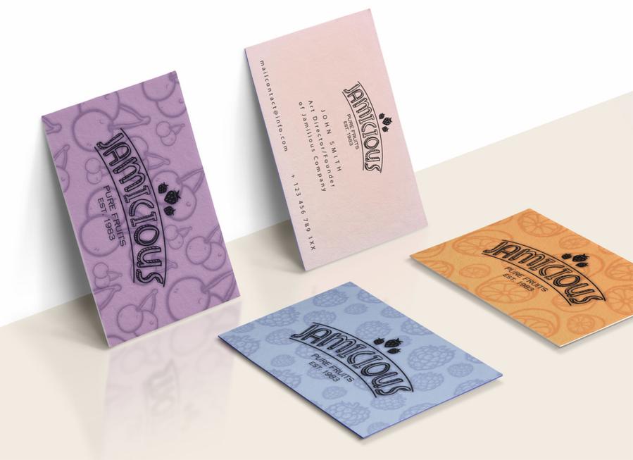 Kolorowe wizytówki firmy Jamicious z owocowymi motywami, leżące na jasnym tle. Różne warianty kolorystyczne i graficzne, prezentacja projektu wizualnego firmy.