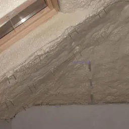 Poddasze ocieplone natryskową pianką poliuretanową PUR, widoczne metalowe elementy mocujące siatkę pod tynk.