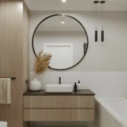 Nowoczesna łazienka z drewnianą szafką pod umywalką, okrągłym lustrem w czarnej ramie, minimalistycznymi lampami wiszącymi i dekoracyjną trawą pampasową w białym wazonie.