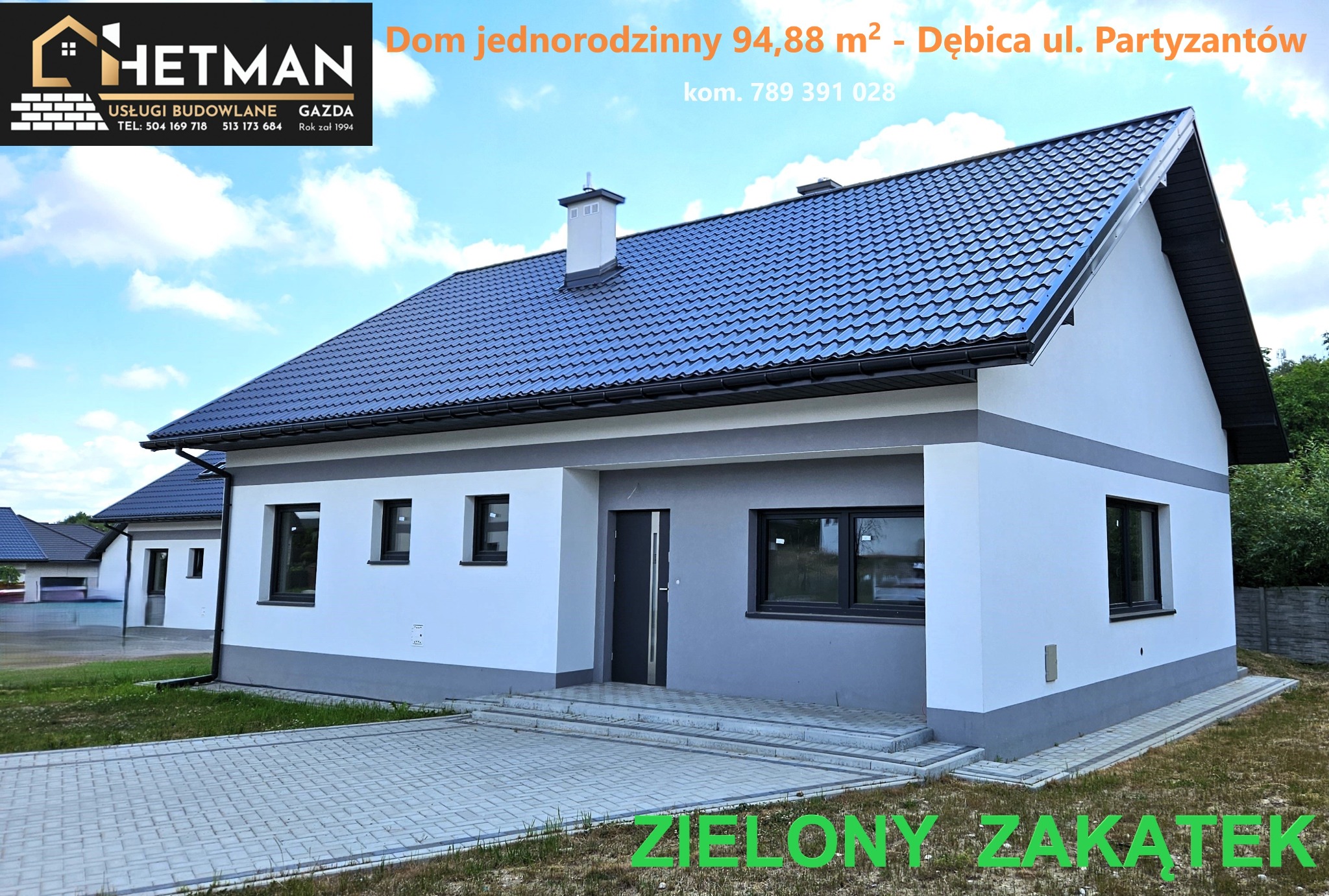 Nowoczesny, parterowy dom jednorodzinny z ciemną dachówką i szarymi elementami wykończeniowymi, prezentowany z zewnątrz, z widocznym logo firmy budowlanej w lewym górnym rogu i adresem na dachu.