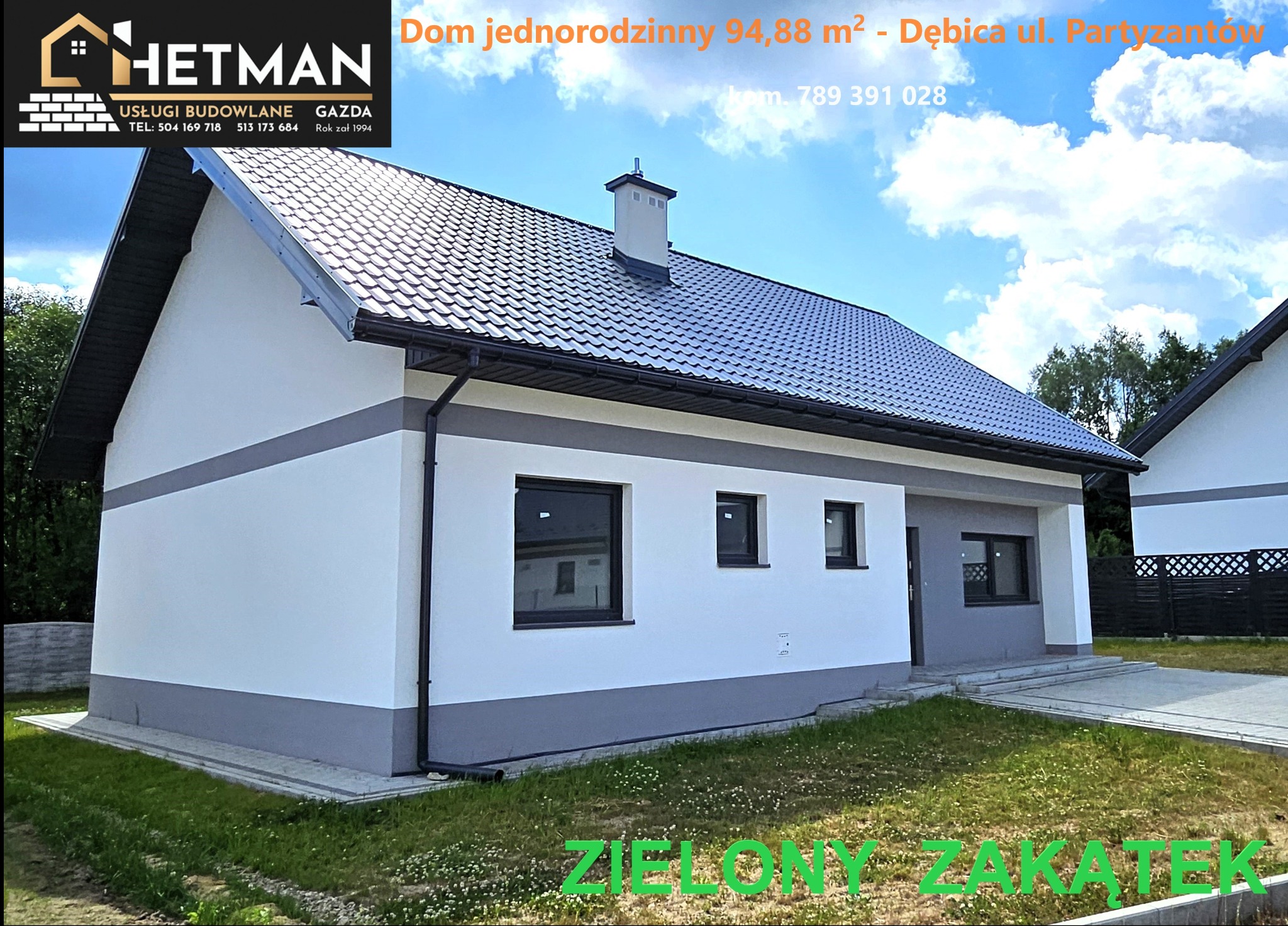 Nowoczesny parterowy dom jednorodzinny z ciemną dachówką, szarą podmurówką i białymi ścianami, widok z boku na tle zieleni.