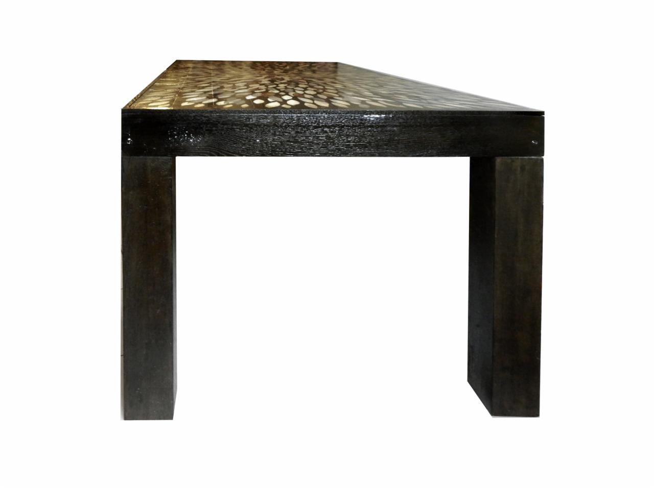 Stół do jadalni z ciemnego drewna z blatem zdobionym wzorem przypominającym kamienie rzeczne, widok z boku, minimalistyczny design.