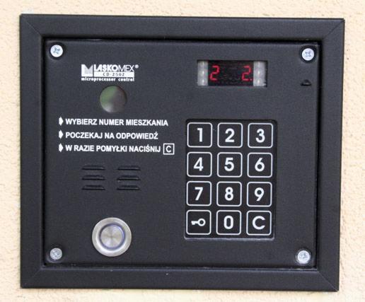 Czarny panel domofonowy Laskomex CD-2502 z klawiaturą numeryczną, zamontowany w Gdańsku. Widoczne instrukcje wyboru numeru mieszkania i oczekiwania na odpowiedź.