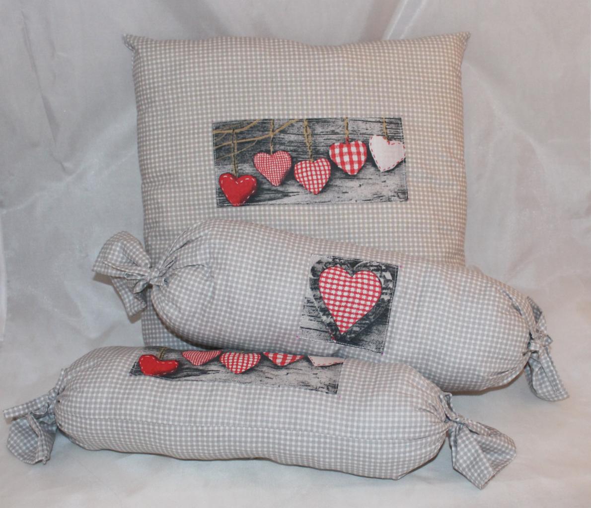 Dekoracyjne poduszki w kratę z motywem serc, tworzące przytulny zestaw. Idealne jako ozdoba wnętrza lub element prezentu okolicznościowego.