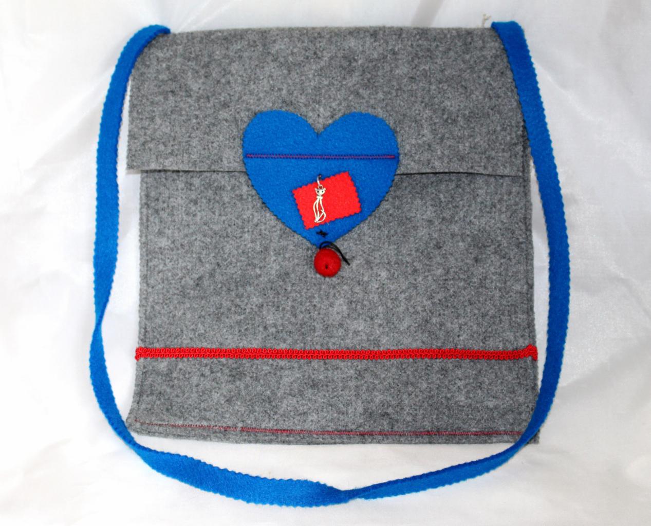 Filcowa torba na prezent w szarym kolorze, ozdobiona niebieskim sercem i czerwoną wstążką, idealna na specjalną okazję.