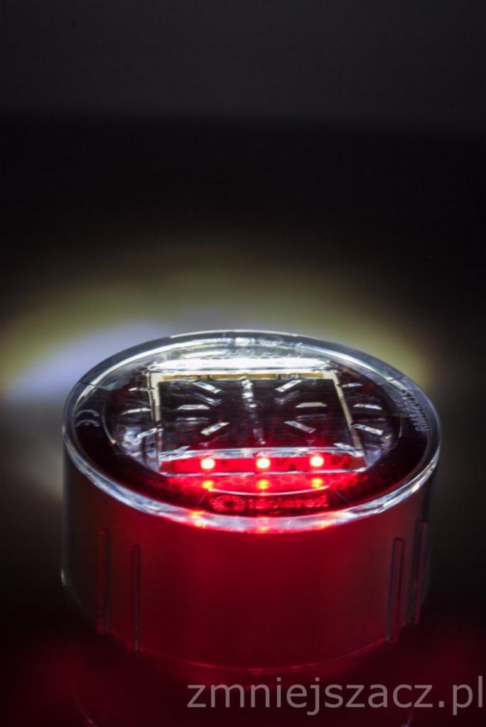 Niski, okrągły, czerwony odblaskowy element drogowy z panelem słonecznym i trzema czerwonymi diodami LED