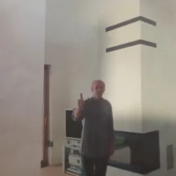 Mężczyzna z uniesionym kciukiem na tle świeżo pomalowanego, białego pokoju z dekoracyjnymi, czarnymi pasami na ścianach i nowoczesnym kominkiem.