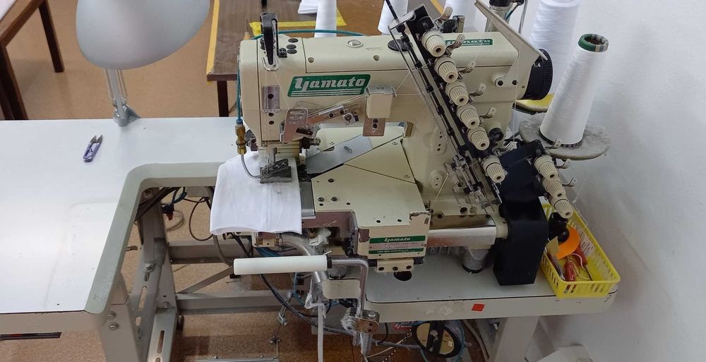 Profesjonalna owerlok Yamato w Mławie, z nawleczonymi nićmi i fragmentem białego materiału pod stopką, gotowa do szycia.