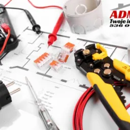 Multimetr, wago, wtyczka, próbnik napięcia, ściągacz izolacji i puszka elektryczna na planie instalacji elektrycznej, obok logo firmy Admar.
