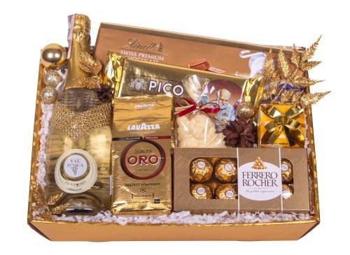 Złoty, luksusowy zestaw prezentowy z szampanem Val D'Oca, kawą Lavazza Oro, czekoladkami Lindt i Ferrero Rocher, zapakowany w ozdobny karton z dekoracjami.