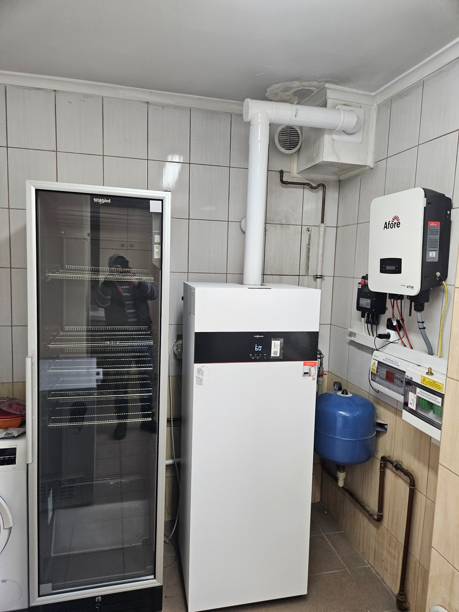 Biały piec grzewczy Viessmann z podłączeniami, obok szafa chłodnicza i inwerter Afore, Bielawa. Instalacja w pomieszczeniu z kafelkami.
