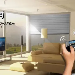 Chłopiec trzymający smartfon z aplikacją do sterowania inteligentnym domem Fibaro, widoczny panel sterowania na ścianie, rolety okienne i telewizor w nowoczesnym salonie.