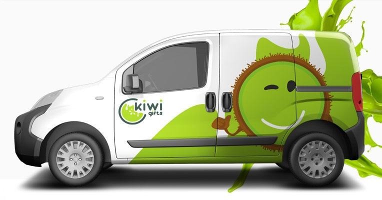 Biały samochód dostawczy z zielonym motywem kiwi, logo 'kiwi gifts' i graficznymi plamami farby w tle.