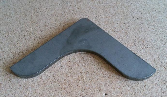 Metalowy kątownik ślusarski z zaokrąglonymi krawędziami na korkowej podkładce. Narzędzie pomiarowe w obróbce metali.