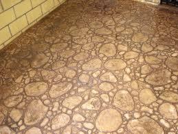 Wykończona posadzka imitująca kamienny bruk na tarasie z ceglaną ścianą. Realizacja z bliska, ukazująca detale wzoru i fakturę powierzchni.